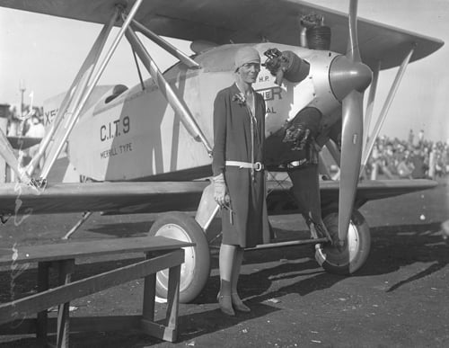 Amelia Earhart standing infront of plane circa 1928